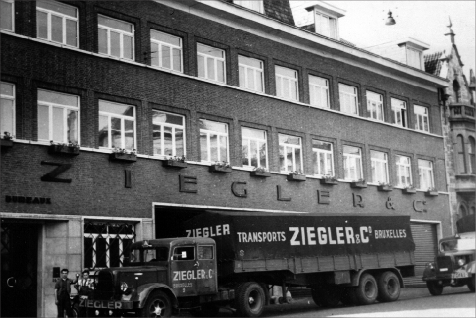 An early Ziegler building in the streets of Germany with a Ziegler transport vehicle outside